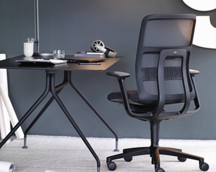 Schwarzer Bürostuhl mit Netzrücken und verstellbaren Armlehnen neben einem modernen, schwarzen Schreibtisch. Ergonomischer Bürostuhl für komfortables Arbeiten.