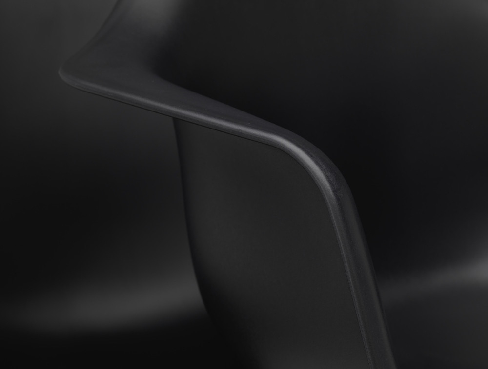 Detailaufnahme der Armlehne eines schwarzen Eames Plastic Arm Chair PACC Stuhls von Vitra.
