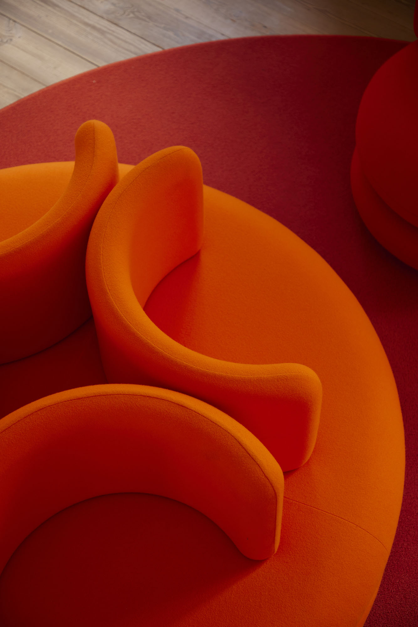 Nahaufnahme des orangefarbenen Easy Sofa Verpan Modulsofas auf rotem Teppich, modernes Wohnzimmer Design.