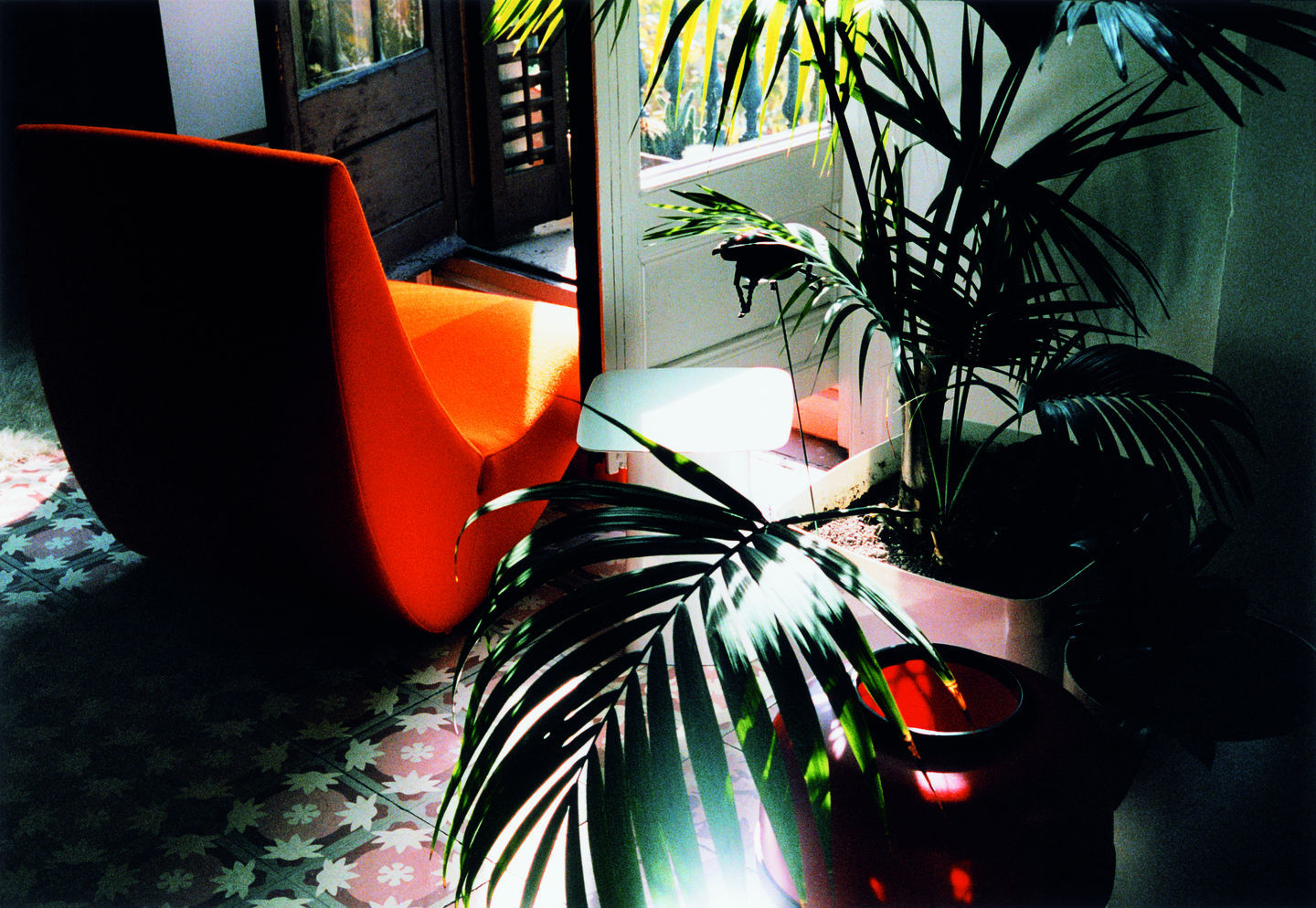 Oranger Amoebe Sessel von Vitra im Interieur mit Pflanzen und gemustertem Boden.