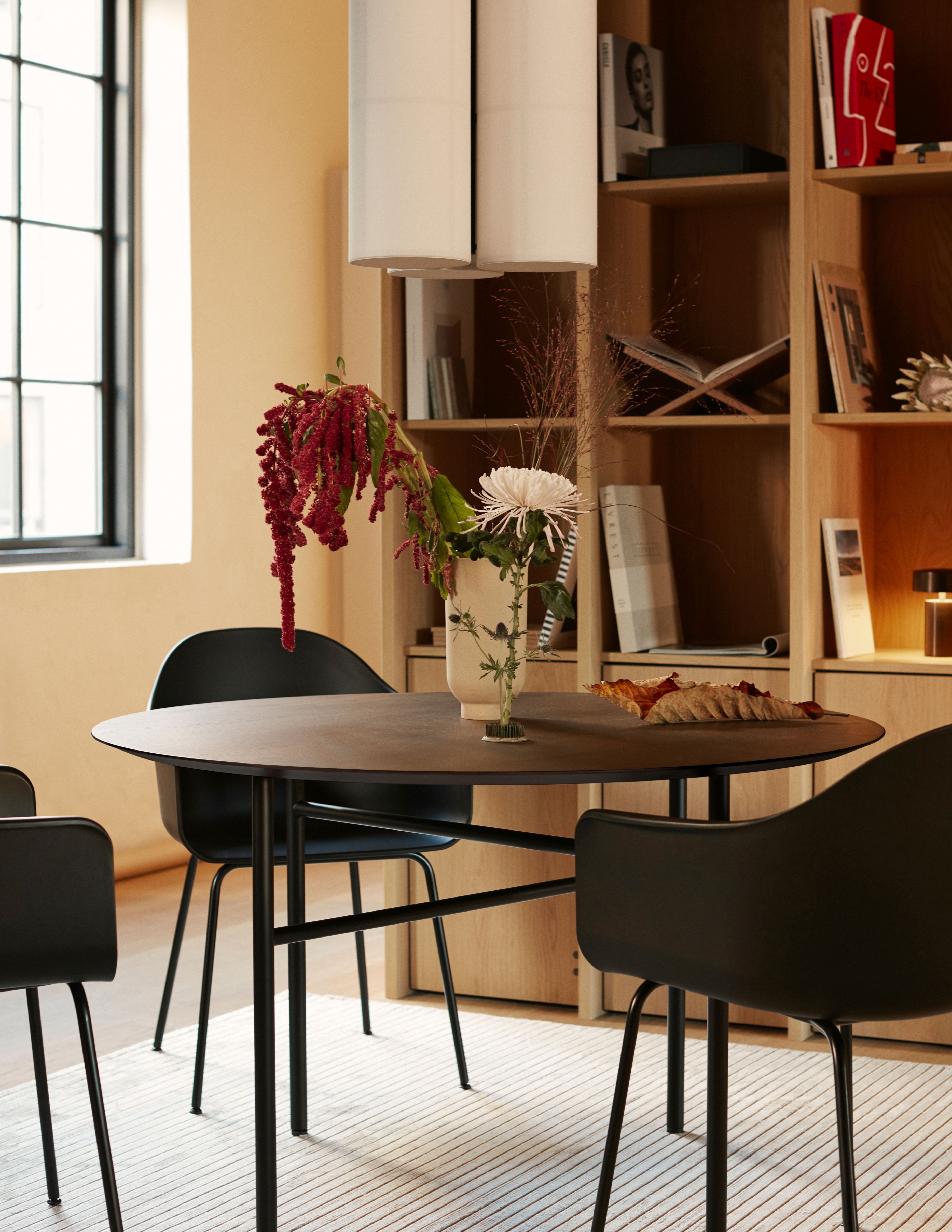 Esszimmer mit Hashira Pendelleuchten Cluster, runder Tisch und schwarzen Stühlen. Moderne Innenarchitektur.