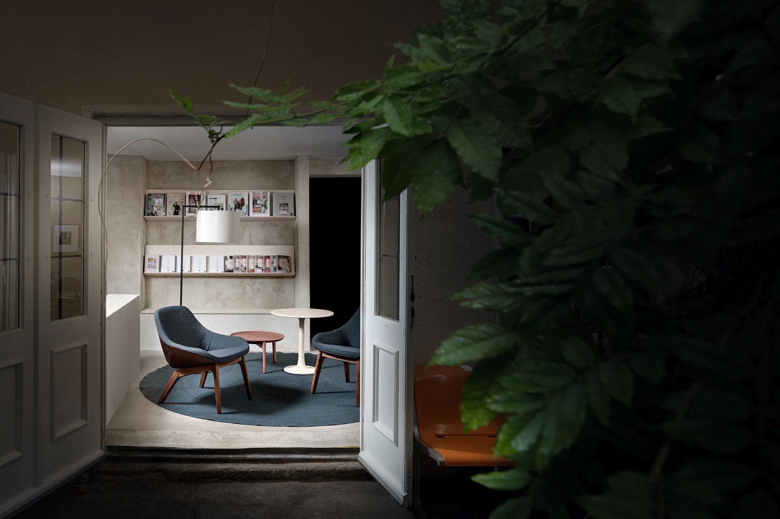 Turntable Esstisch Zeitraum: Runder Esstisch mit Stühlen und Teppich in modernem Interieur, gesehen durch eine offene Tür.