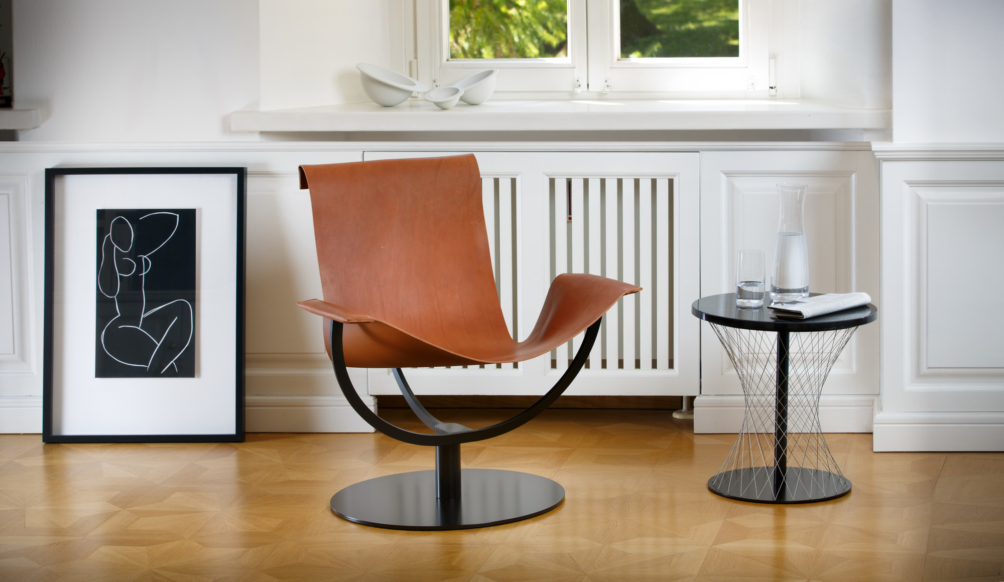 Arch Chair Sessel Favius aus braunem Leder mit schwarzem Metallgestell in modernem Wohnzimmer.