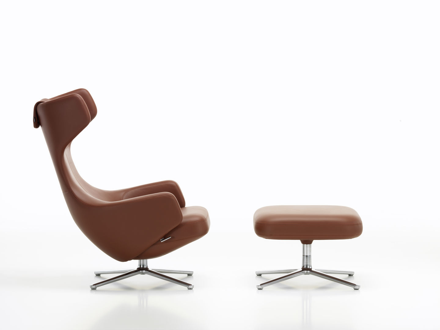 Vitra Grand Repos Sessel mit Ottoman in braunem Leder und silbernem Fußkreuz, seitliche Ansicht.