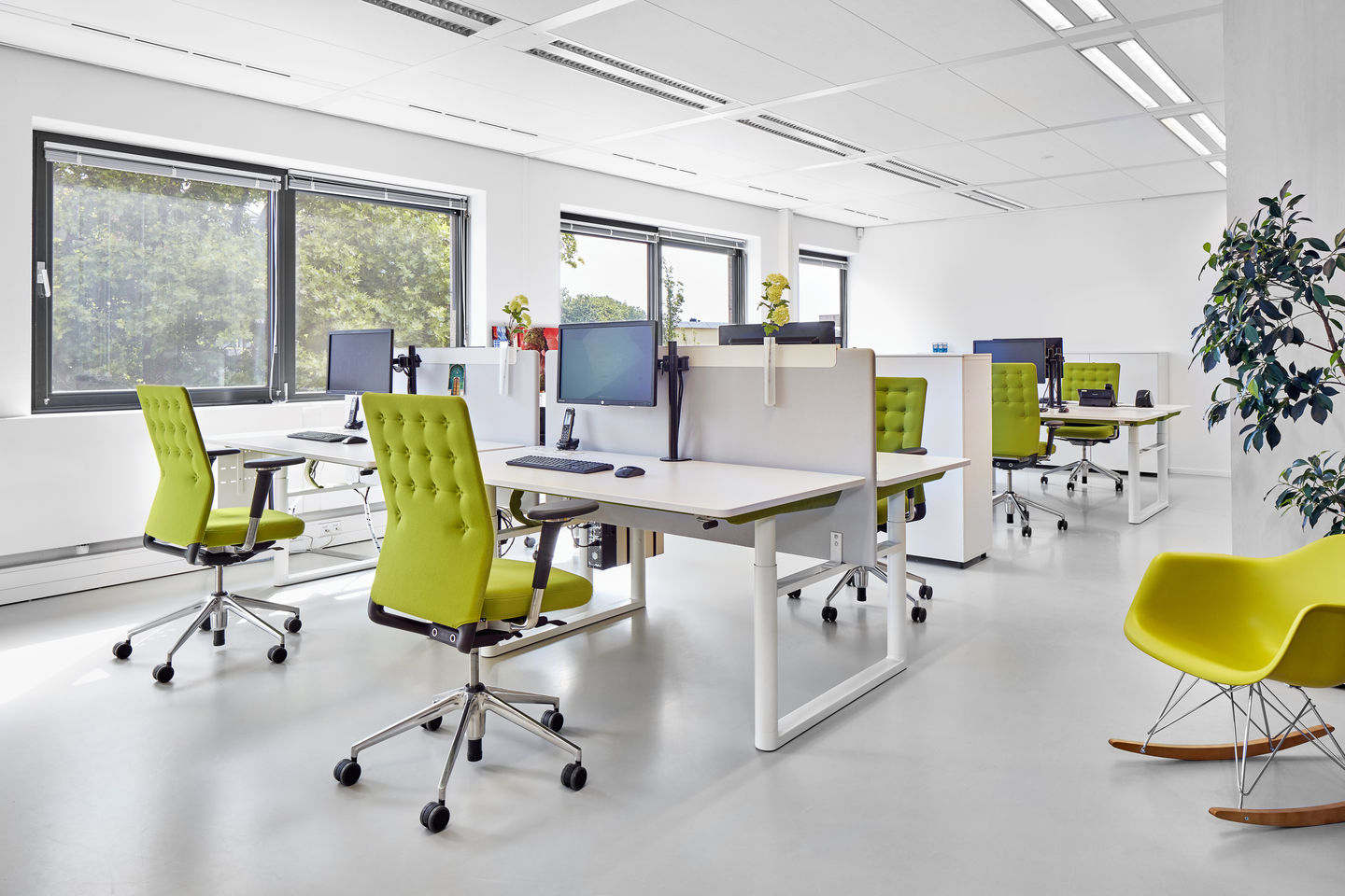 Helles Büro mit mehreren ID Chair - ID Trim Bürodrehstühlen von Vitra in Limettengrün an weißen Schreibtischen.