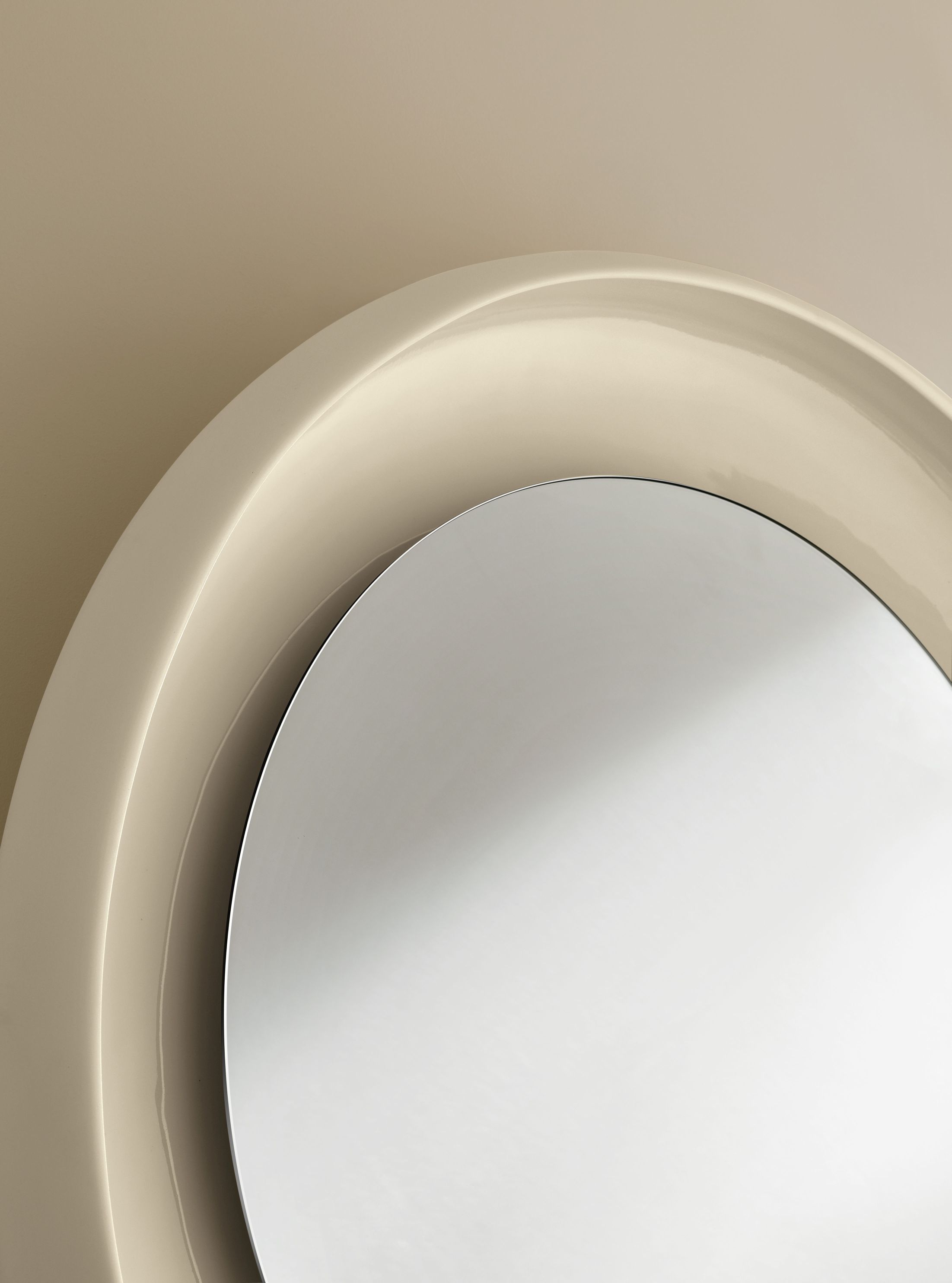 Detailaufnahme des Coque Spiegels von Miniforms mit beigem Keramikrahmen und runder Spiegelfläche.