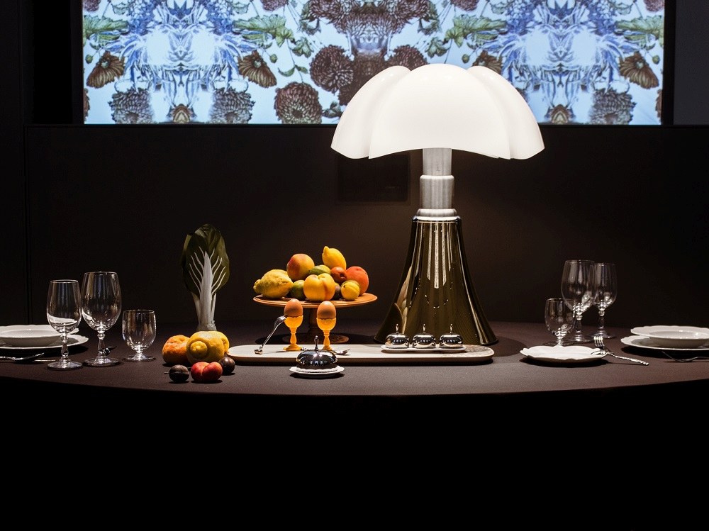 Nahaufnahme der Martinelli Luce Pipistrello Tischleuchte auf einem gedeckten Tisch mit Obst und Geschirr.