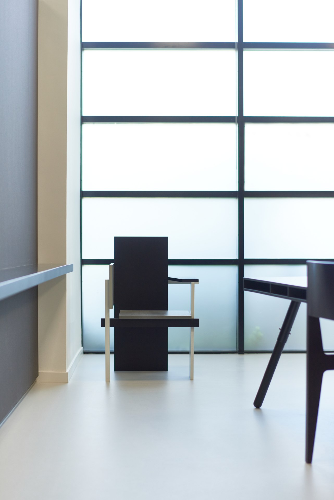 Berlin Stuhl Spectrum: Moderner Designstuhl in Schwarz und Weiß vor Fenster, minimalistisches Möbelstück.