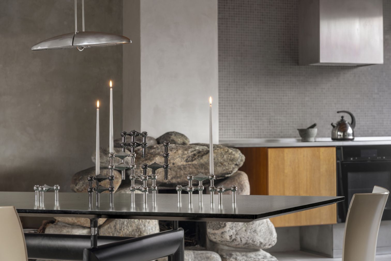 Kerzenständer 3er Set Chrom Stoff Nagel auf Esstisch mit brennenden Kerzen, moderne Raumdekoration.
