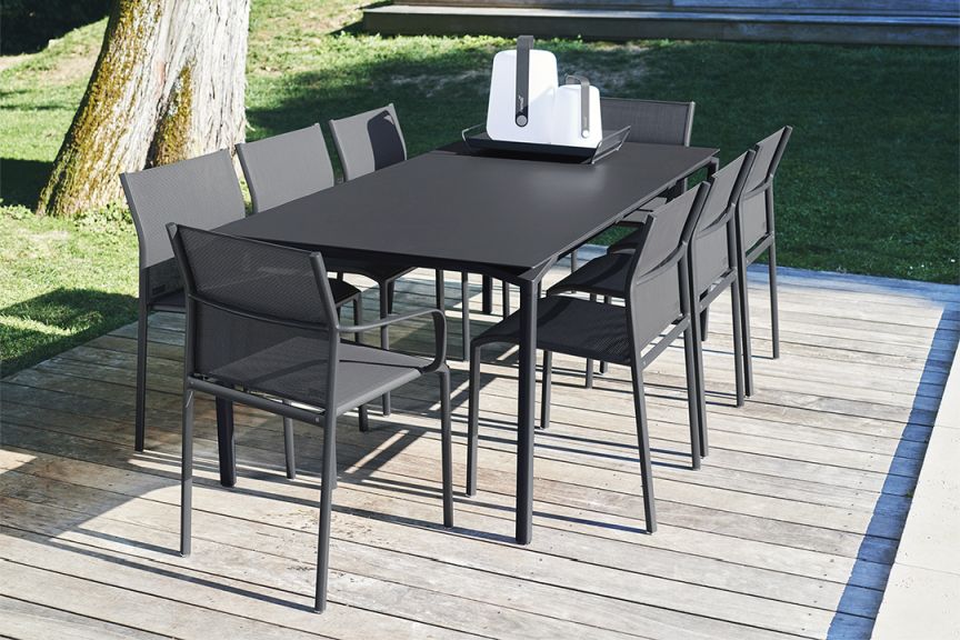 Schwarzkirschefarbener Cadiz Armlehnenstuhl von Fermob für den Außenbereich, Teil einer modernen Gartengarnitur auf Holzterrasse.
