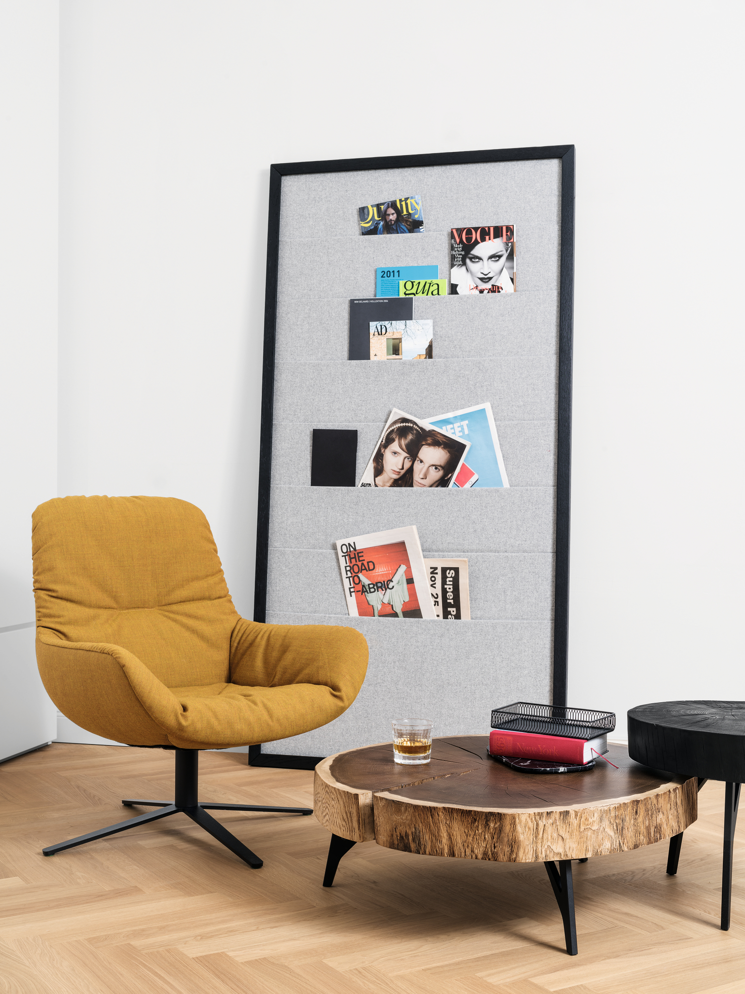 Janua Stomp Beistelltisch H40 aus rohem Holz neben gelbem Sessel und Zeitschriftenhalter.