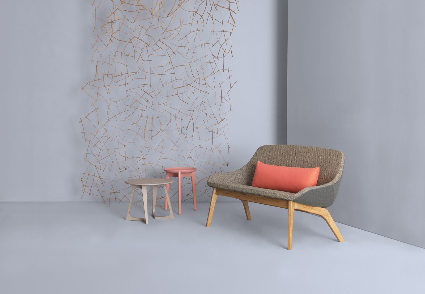 Morph Duo Lounge Sessel von Zeitraum mit orangefarbenem Kissen und Beistelltischen in modernem, grauem Ambiente.