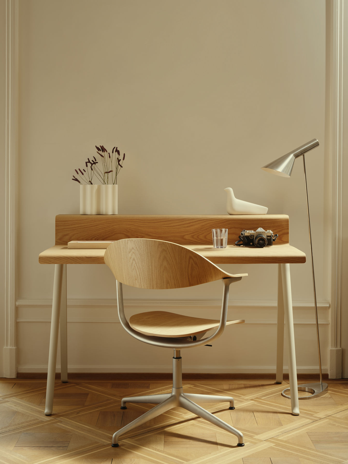 Mynt Bürodrehstuhl von Vitra aus hellem Schichtholz am Schreibtisch mit Kamera und Lampe.