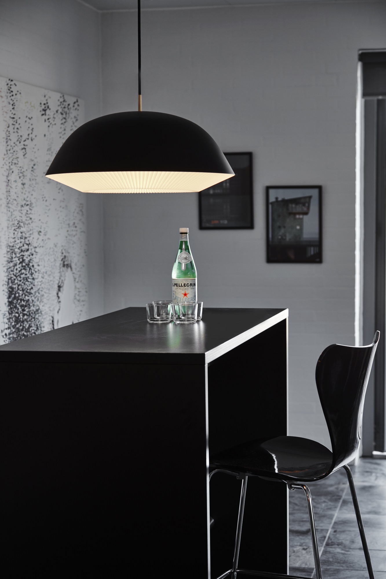 Schwarze Cache Pendelleuchte von Le Klint über einer Küchentheke, modernes Design mit Lampenschirm.