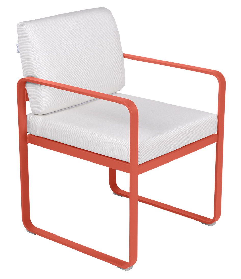 Bellevie Sessel von Fermob für den Außenbereich, orangefarbenes Metallgestell mit weißen Sitz- und Rückenkissen.