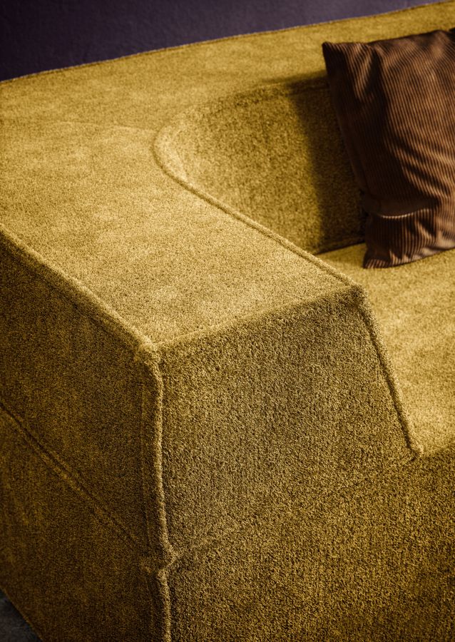 Detailaufnahme des Trio Sofa Eckmoduls in Senfgelb mit braunem Kissen, hochwertige Wohnzimmermöbel.