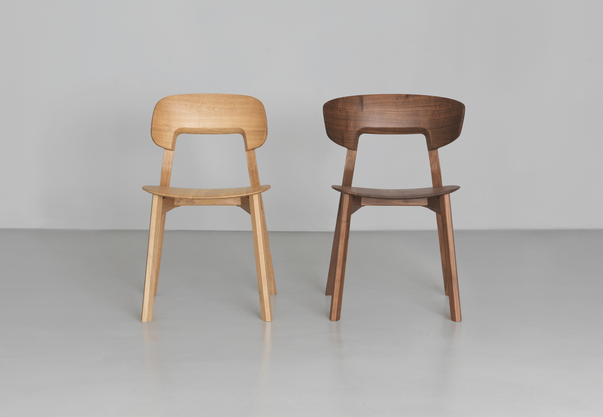 Zwei Nonoto Holzstühle, einer aus hellem, einer aus dunklem Holz, modernes Design.