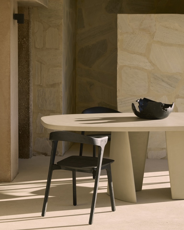 Canyon Outdoor Esstisch von Ethnicraft aus Beton mit Stuhl und Dekoschale im Innenbereich.