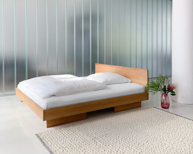 ZIANS Bett Large mit Kopfteil aus hellem Holz und weißer Bettwäsche, minimalistisches Schlafzimmerdesign.