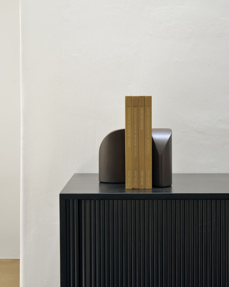 Detailaufnahme der Ethnicraft Roller Max Anrichte in Teak schwarz mit dekorativen Buchstützen und Büchern.