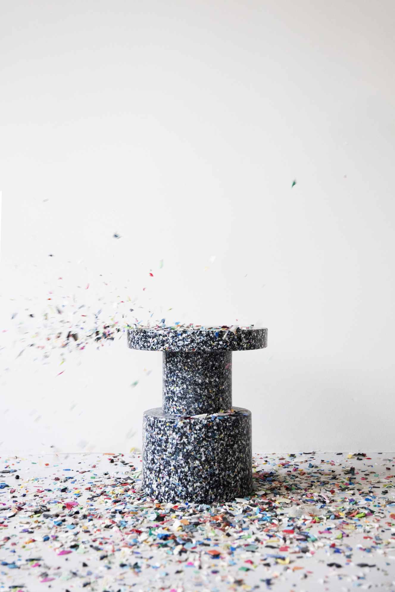 Normann Copenhagen Bit Stool Hocker aus recyceltem Kunststoff mit Konfetti-Effekt vor weißem Hintergrund.