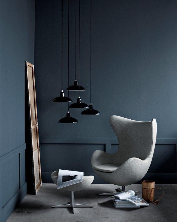 Grauer Egg Chair Sessel mit Hocker von Fritz Hansen in stilvollem, dunklem Ambiente.
