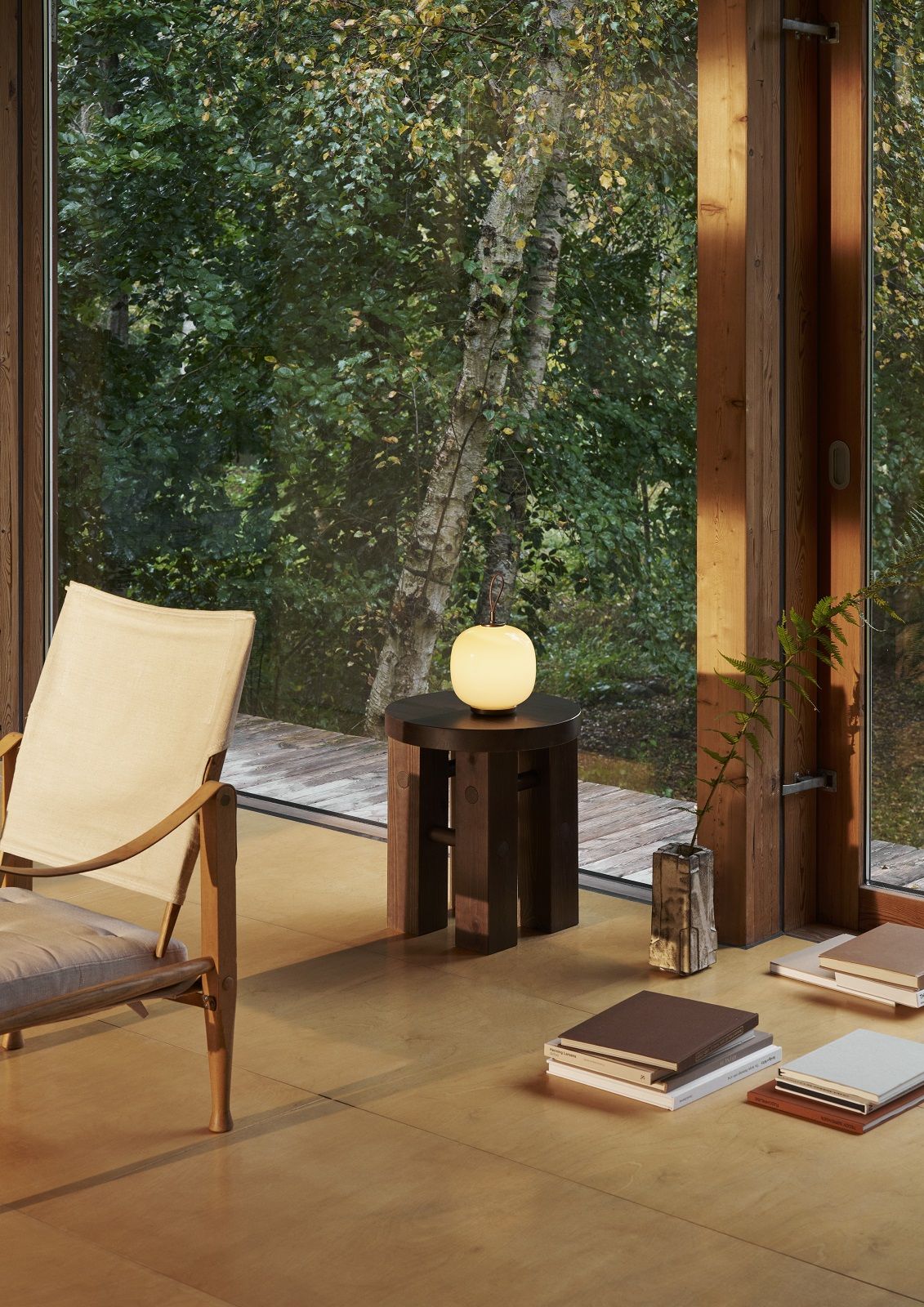 VL 45 Radiohus Tischleuchte von Louis Poulsen als Akku-Version auf dunklem Holzhocker im Wohnraum.