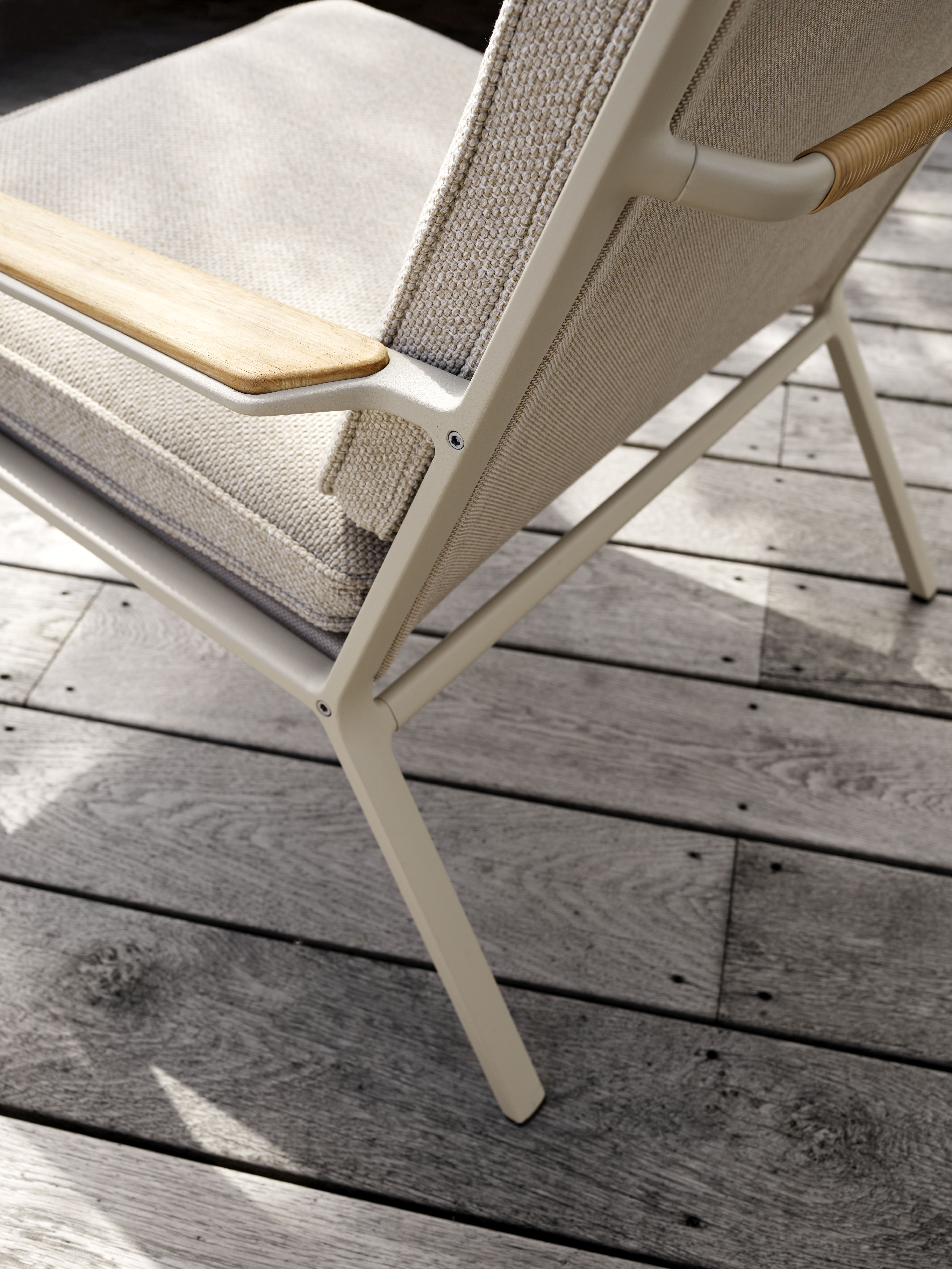 Detailaufnahme des Vipp Open-Air Lounge Stuhls mit Holzarmlehne und bequemen Outdoor-Kissen.