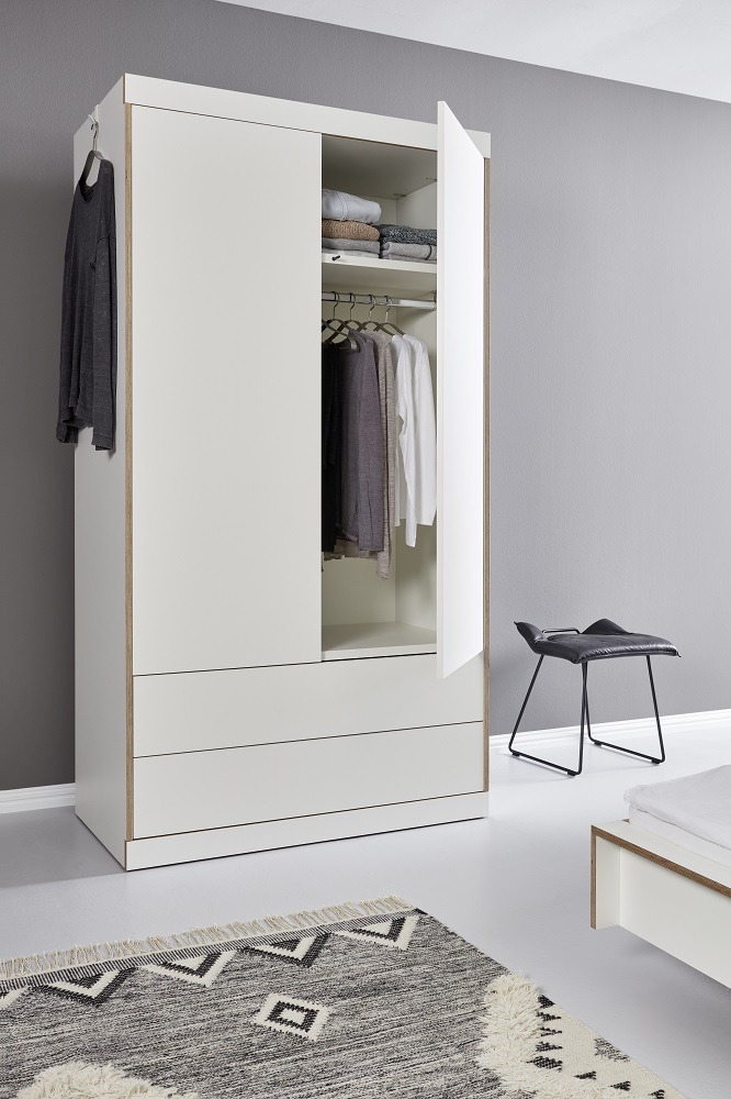 Flai Kleiderschrank von Müller Möbelwerkstätten mit zwei Türen, zwei Schubladen und Kleidung.