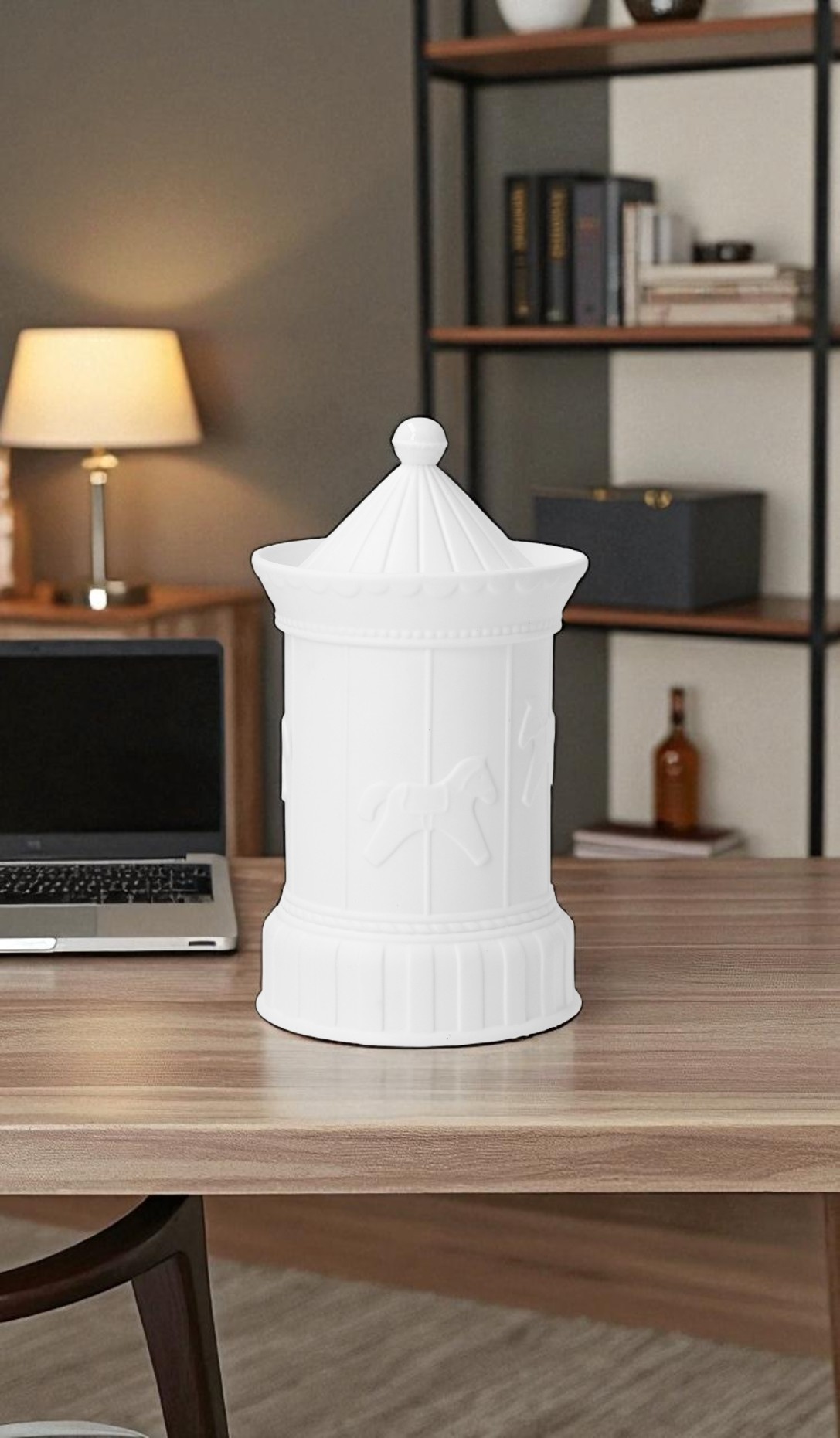 Weiße Karusseldose von RÄDER mit Streifen und Pferde-Motiven als dekoratives Wohnaccessoire auf einem Schreibtisch.