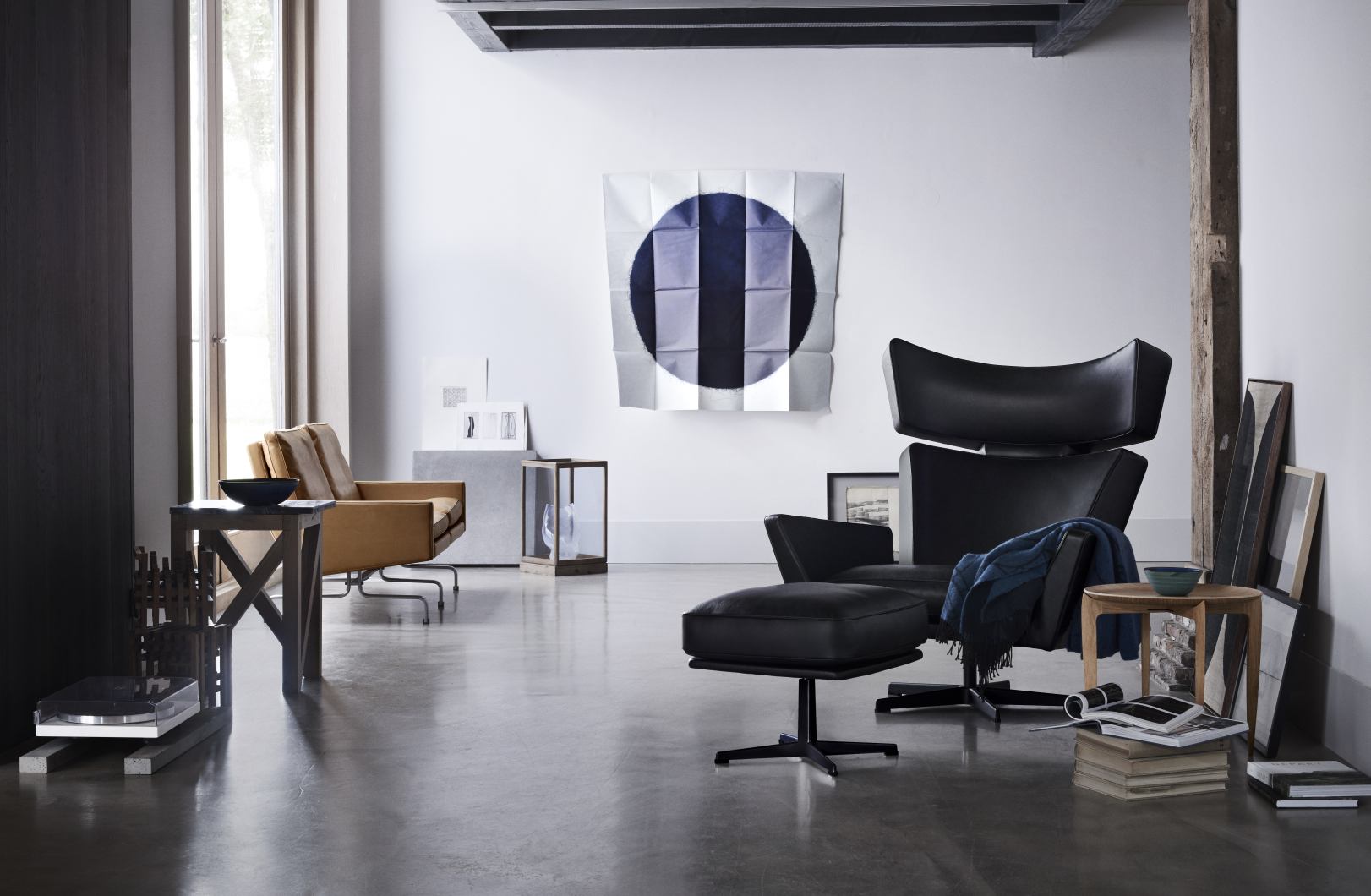 Oksen Sessel von Fritz Hansen mit Hocker in schwarzem Leder in modernem Wohnzimmer.