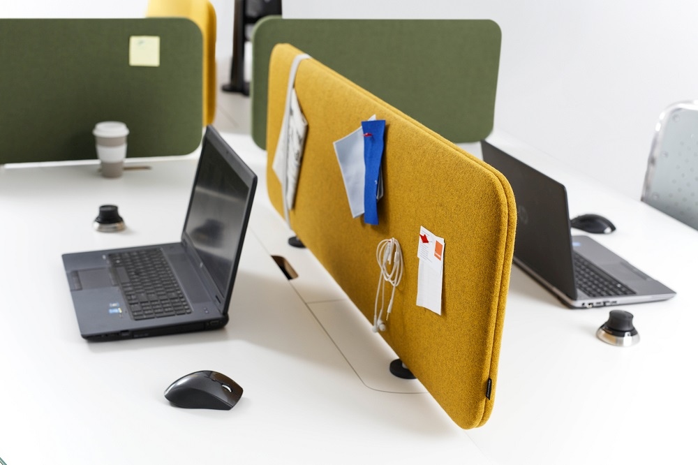 Gelbes Pillow Desk Akustikelement von Cascando am Schreibtisch mit Laptop und Büromaterial. Schallschutz für Büro.