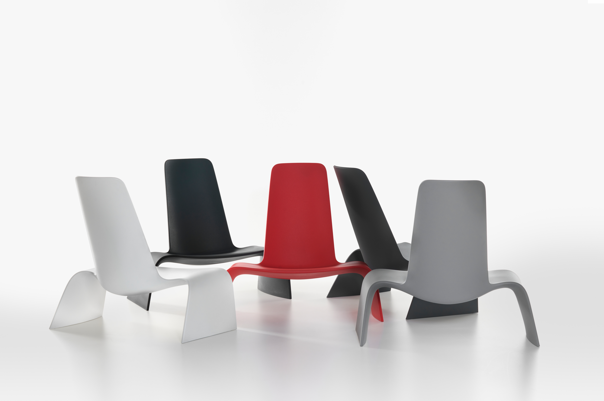 Land Lounge Sessel in Basalt Grau, Weiß, Schwarz und Rot auf weißem Hintergrund.