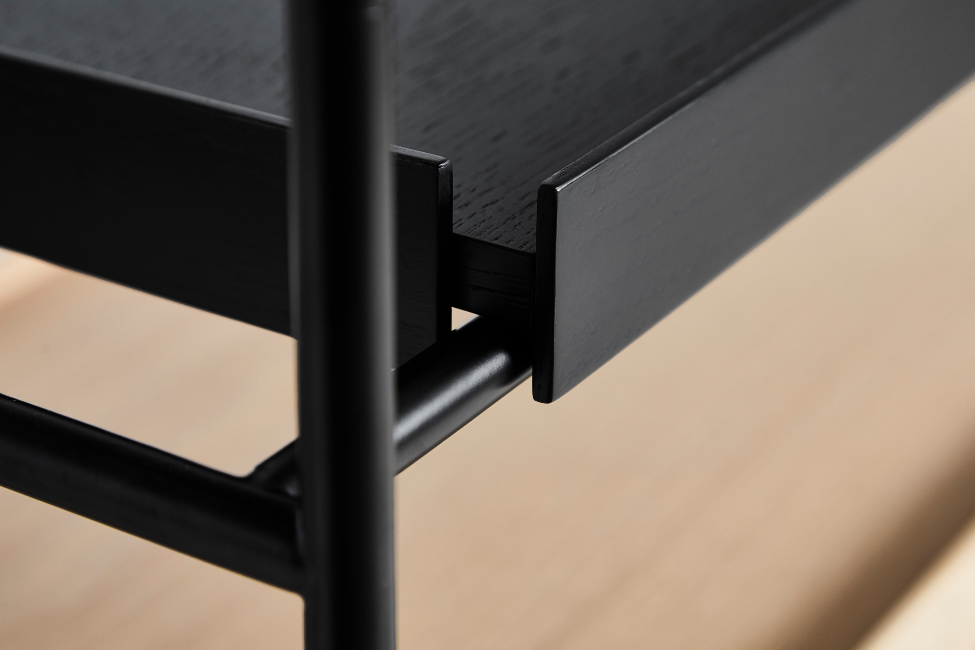Detailaufnahme des schwarzen Tray Shelf Low Regals von Woud, das modernes Design und minimalistische Ästhetik vereint.