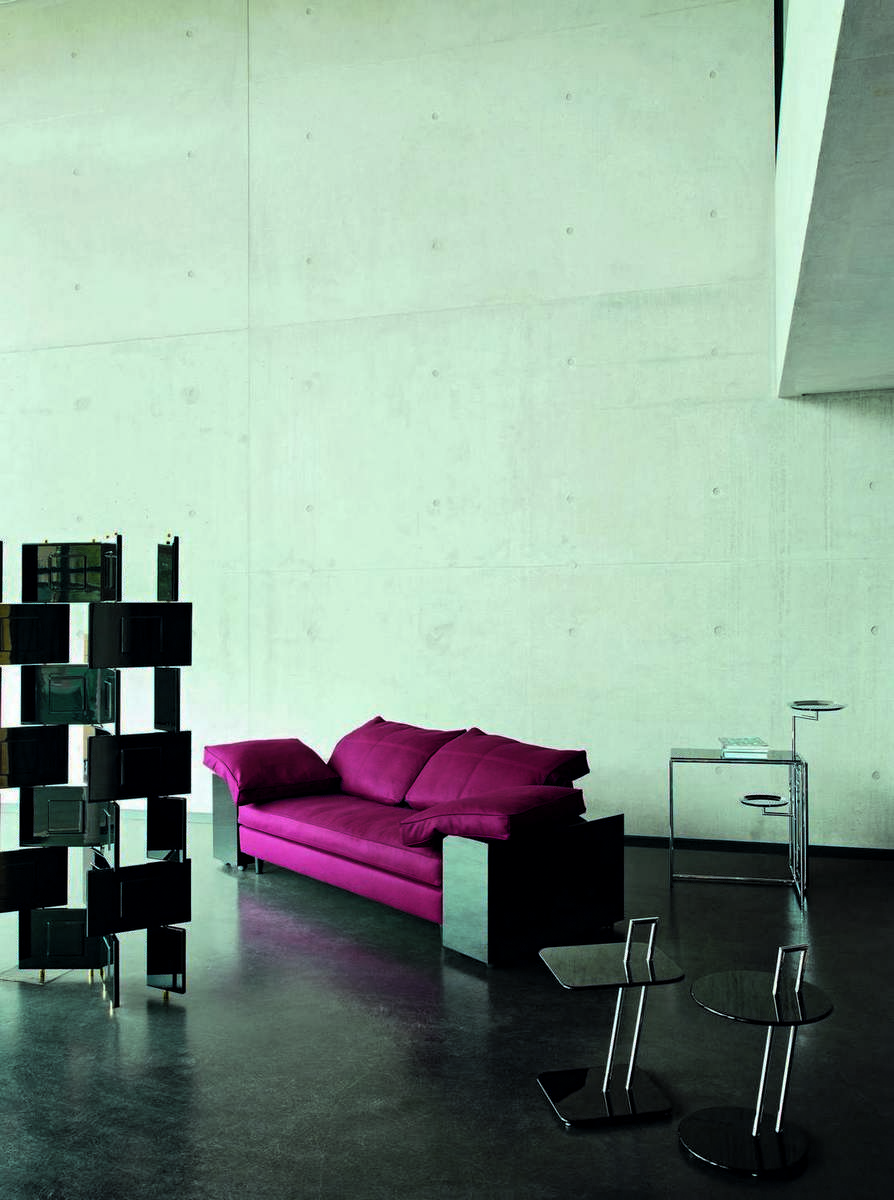Moderner Wohnraum mit ClassiCon Beistelltischen, roten Sofa und Raumteiler. Design Möbel für stilvolles Wohnen.
