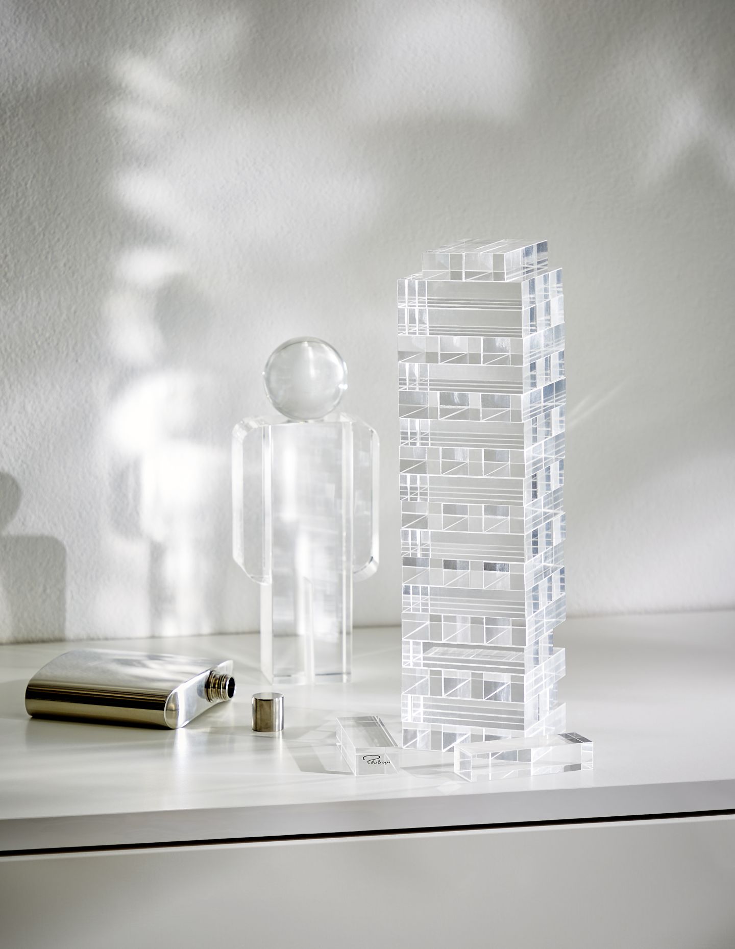 Yap Geschicklichkeitsspiel von Philippi: Turm aus Acrylglas, Figur mit Glaskopf und Edelstahl-Flachmann auf weißem Untergrund.