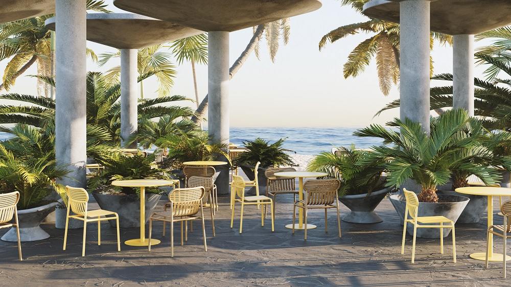 Week-End Stuhl von Petite Friture in Jadegrün mit passendem Tisch auf einer Terrasse am Meer.