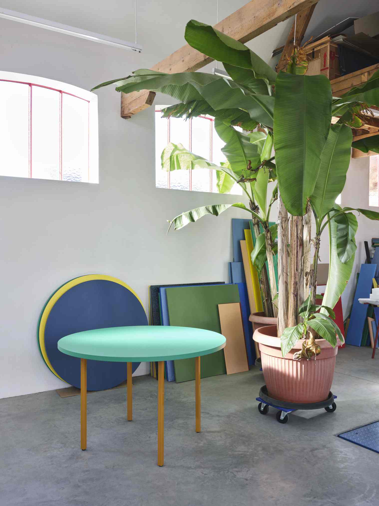 Heller Raum mit HAY Two Colour Table, runder Tisch mit mintgrüner Platte und gelben Beinen.
