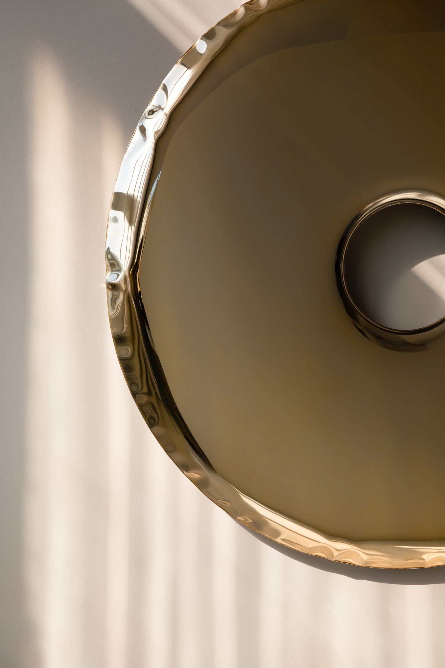 Detailaufnahme des Rondo Spiegels in Aurum Gold von Zieta, ein moderner Wandspiegel mit einzigartiger Oberflächenstruktur.