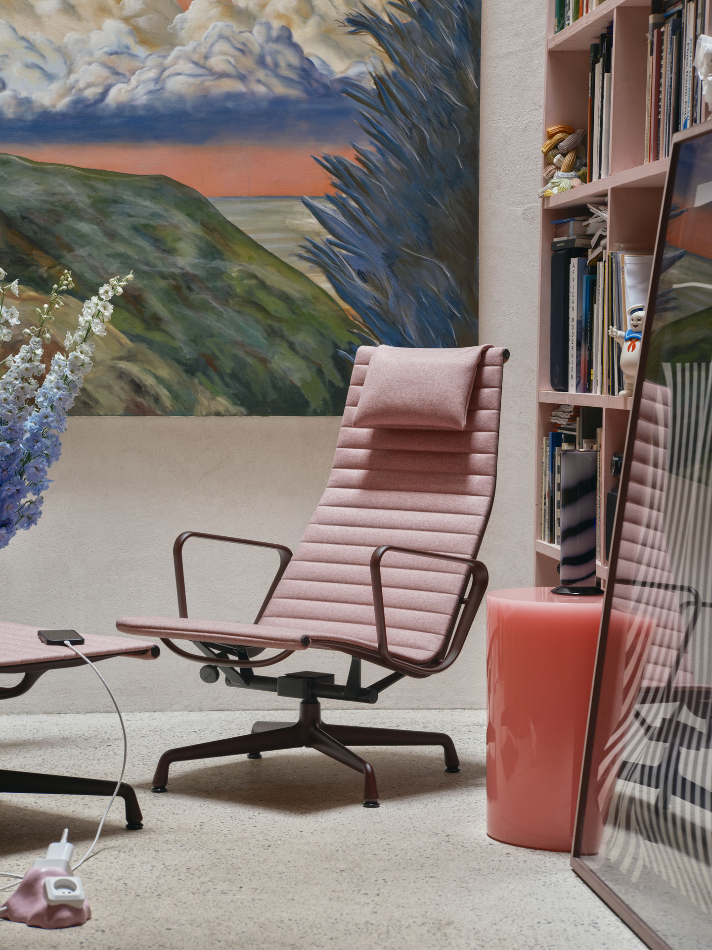 Nahaufnahme des Vitra Aluminium Chair EA 125 mit Hocker in Rosa, stilvolles Designmöbel.
