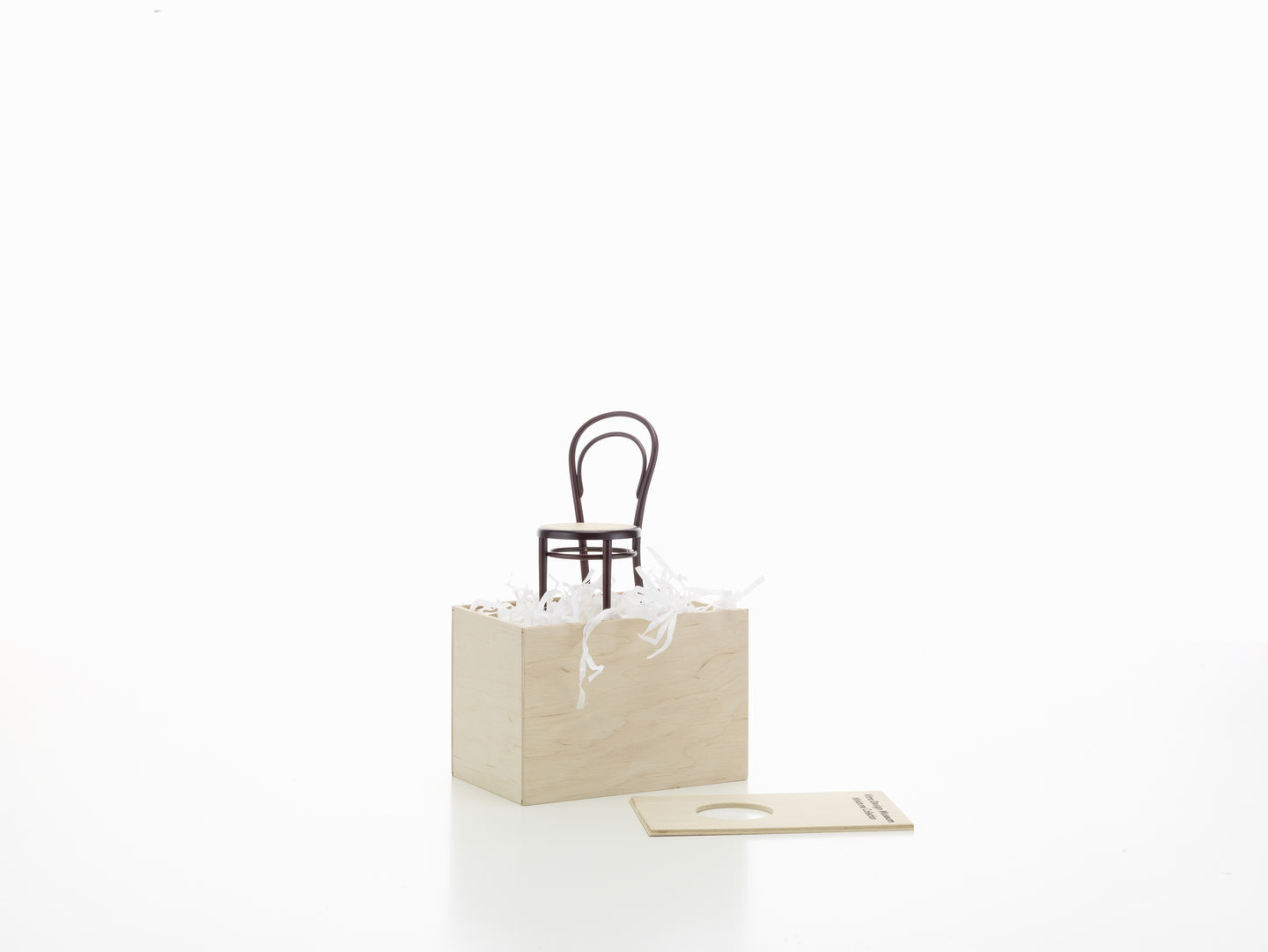 Miniatur Stuhl No. 14 von Vitra auf einer Holzbox mit Füllmaterial. Designklassiker.