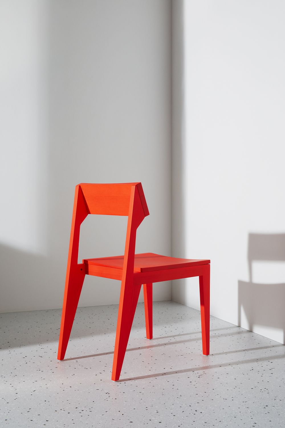 Roter SCHULZ Stuhl mit minimalistischem Design. Moderner Holzstuhl für Esszimmer und Wohnbereich.