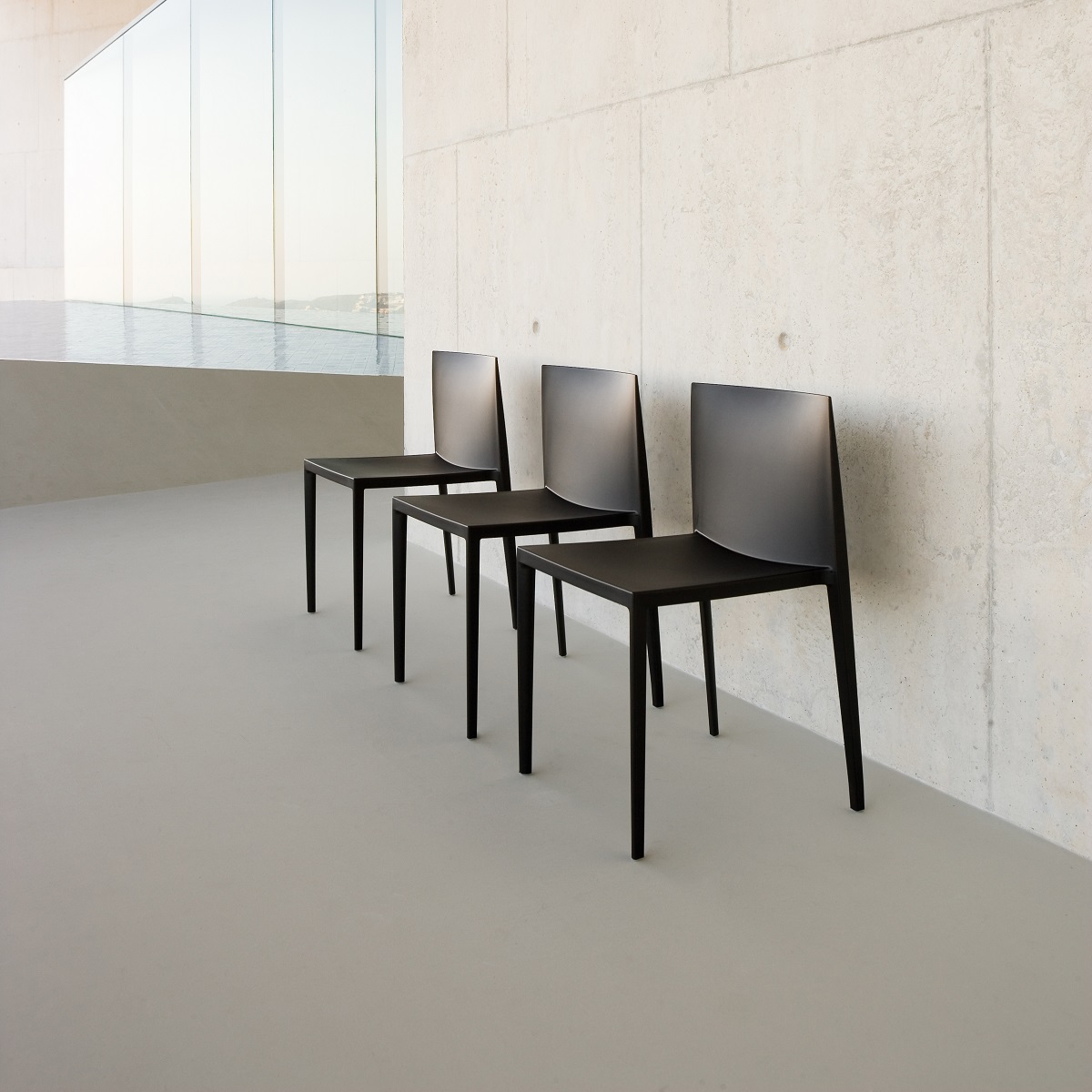Drei schwarze Sail Stühle SI1245 von Andreu World, stapelbare Designstühle für moderne Innenräume.