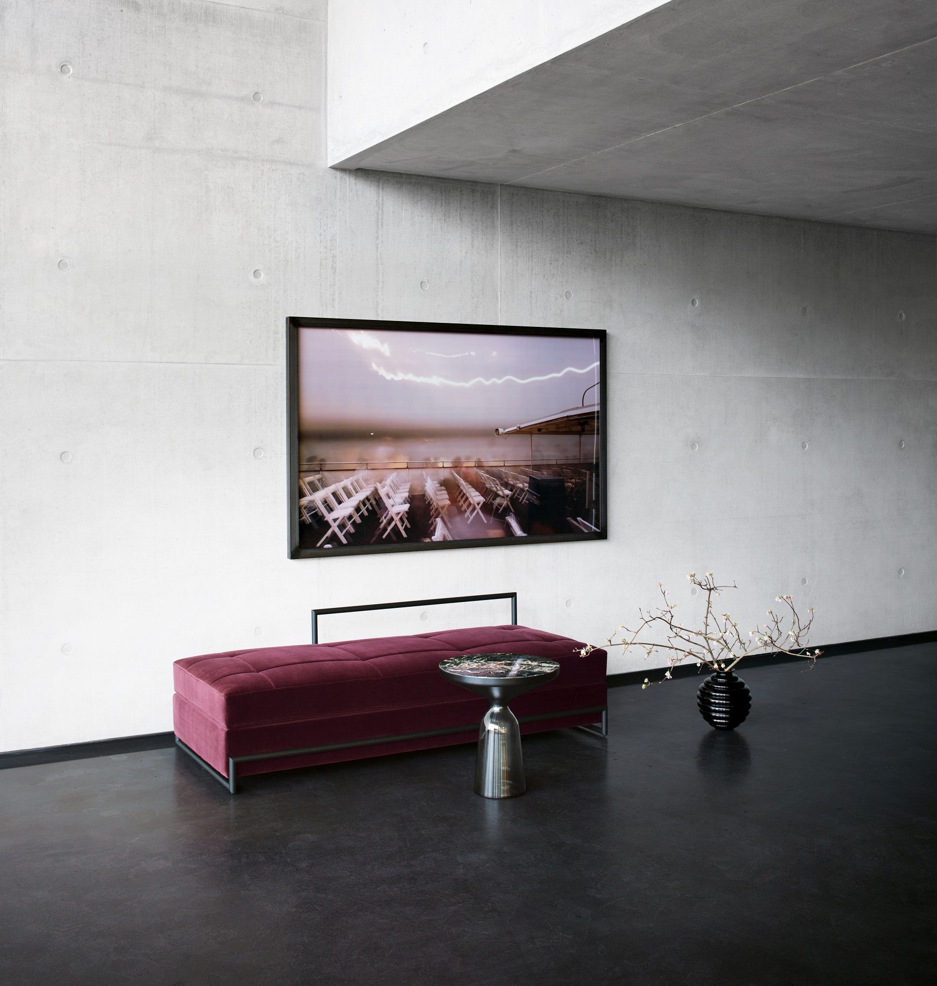 Nahaufnahme des Classicon Day Bed Grand in Bordeauxrot mit Beistelltisch in modernem Interieur.