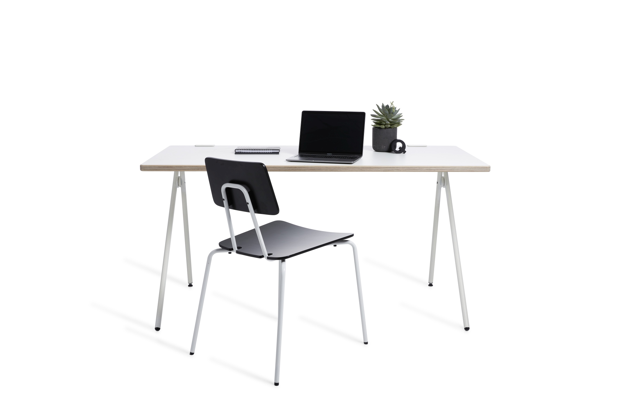 Weißer Schreibtisch mit Laptop, Notizbuch und Pflanze. Plato Schreibtisch von Müller Möbelwerkstätten.