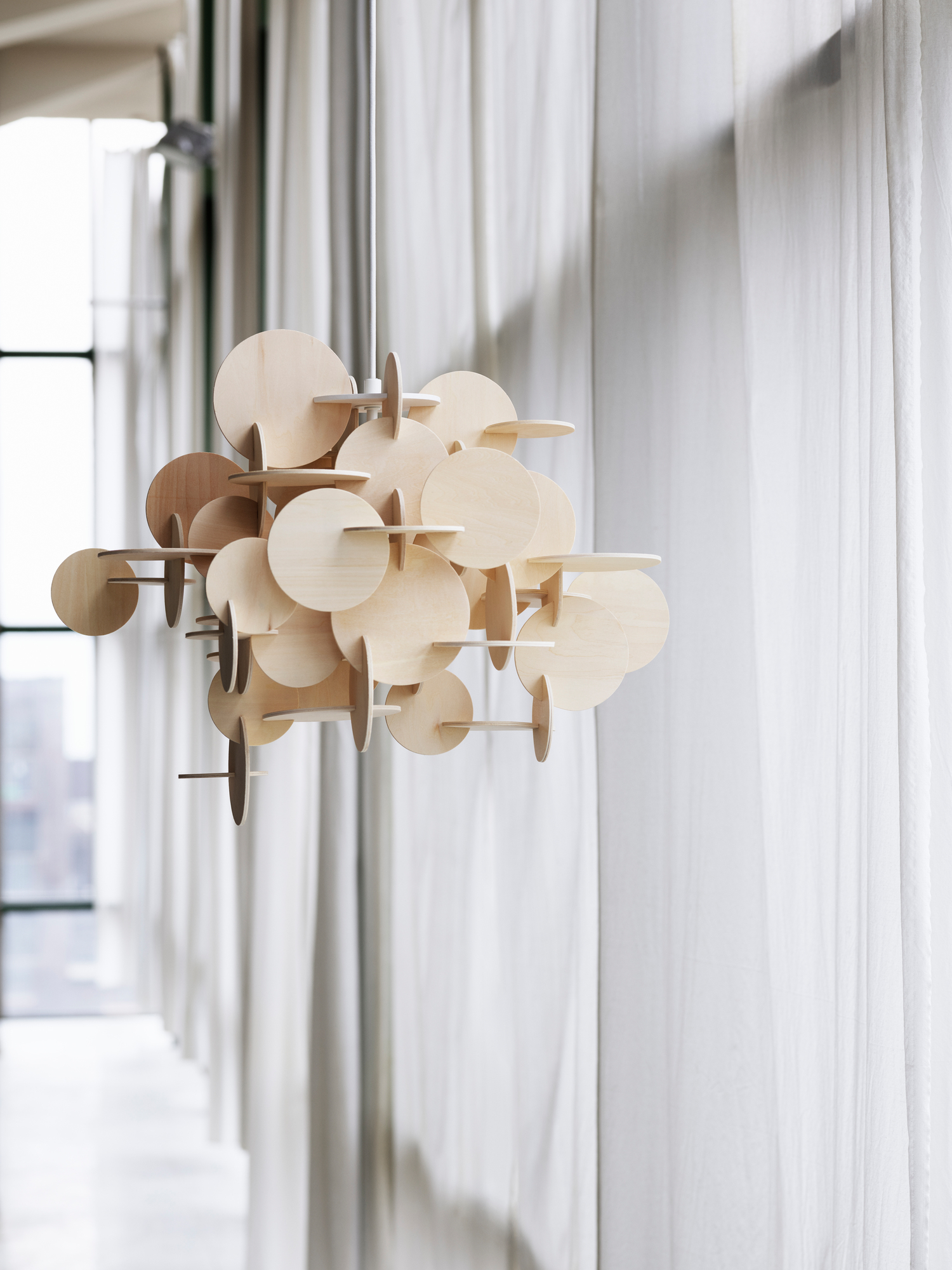 Normann Copenhagen Bau Pendelleuchte aus Holz, moderne Hängelampe mit runden Elementen im Innenraum.