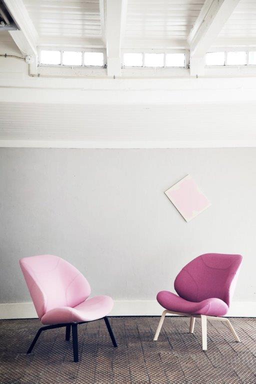 Zwei moderne Eden Sessel von Softline in Rosa und Lila vor einer grauen Wand.