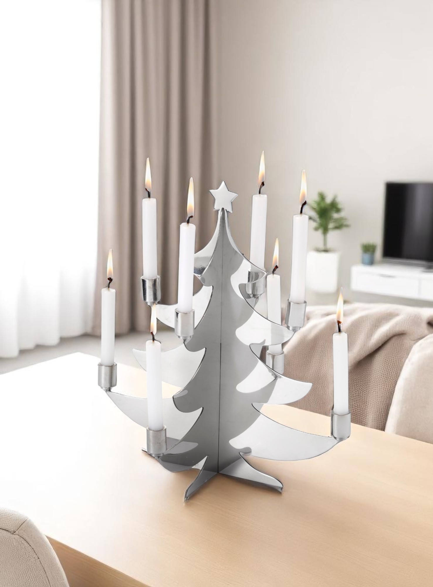 Grenoble Weihnachtsbaum Kerzenhalter von Philippi aus poliertem Edelstahl mit brennenden, weißen Kerzen auf einem Holztisch.
