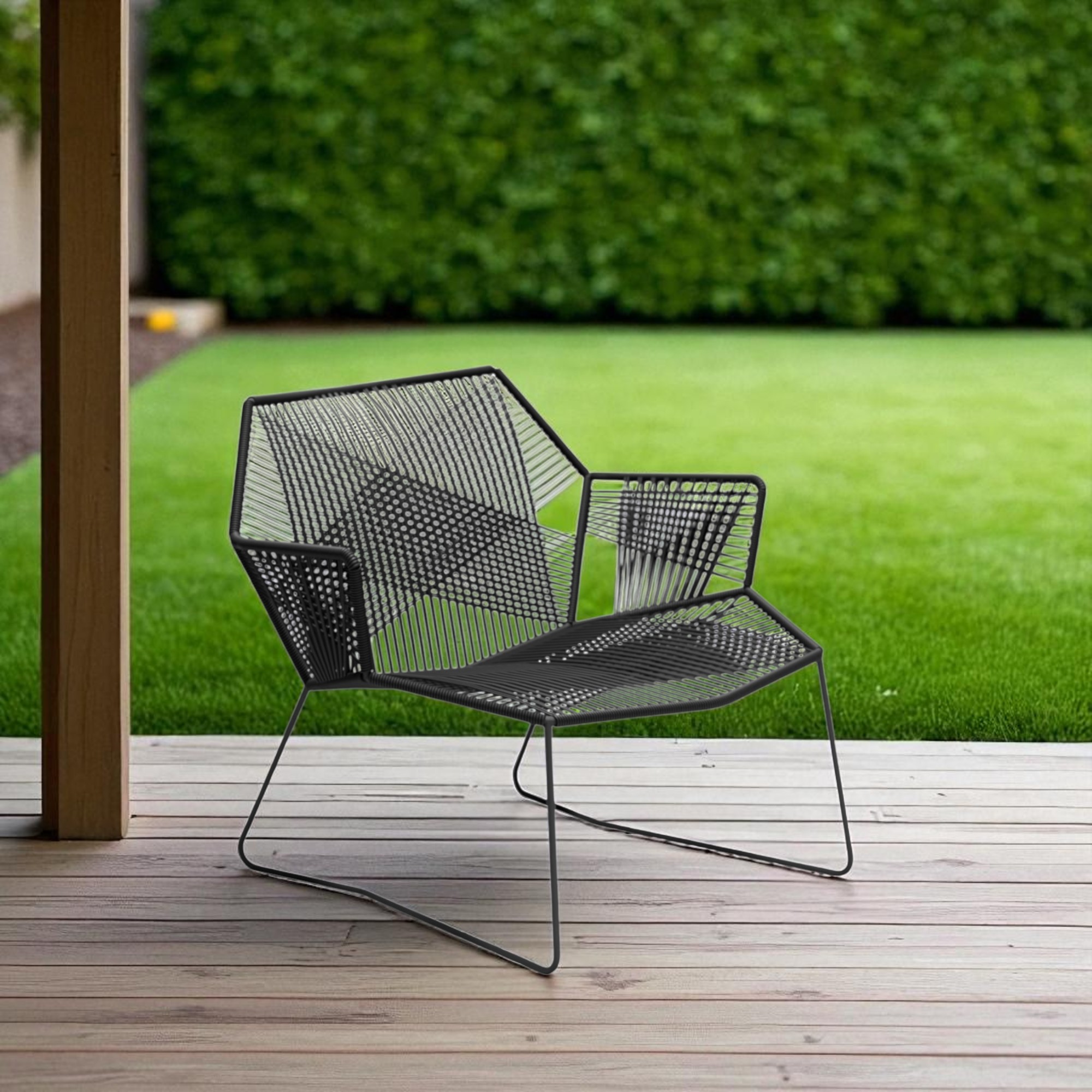 Schwarzer Tropicalia Sessel von Moroso für den Außenbereich auf einer Holzterrasse vor grünem Rasen.