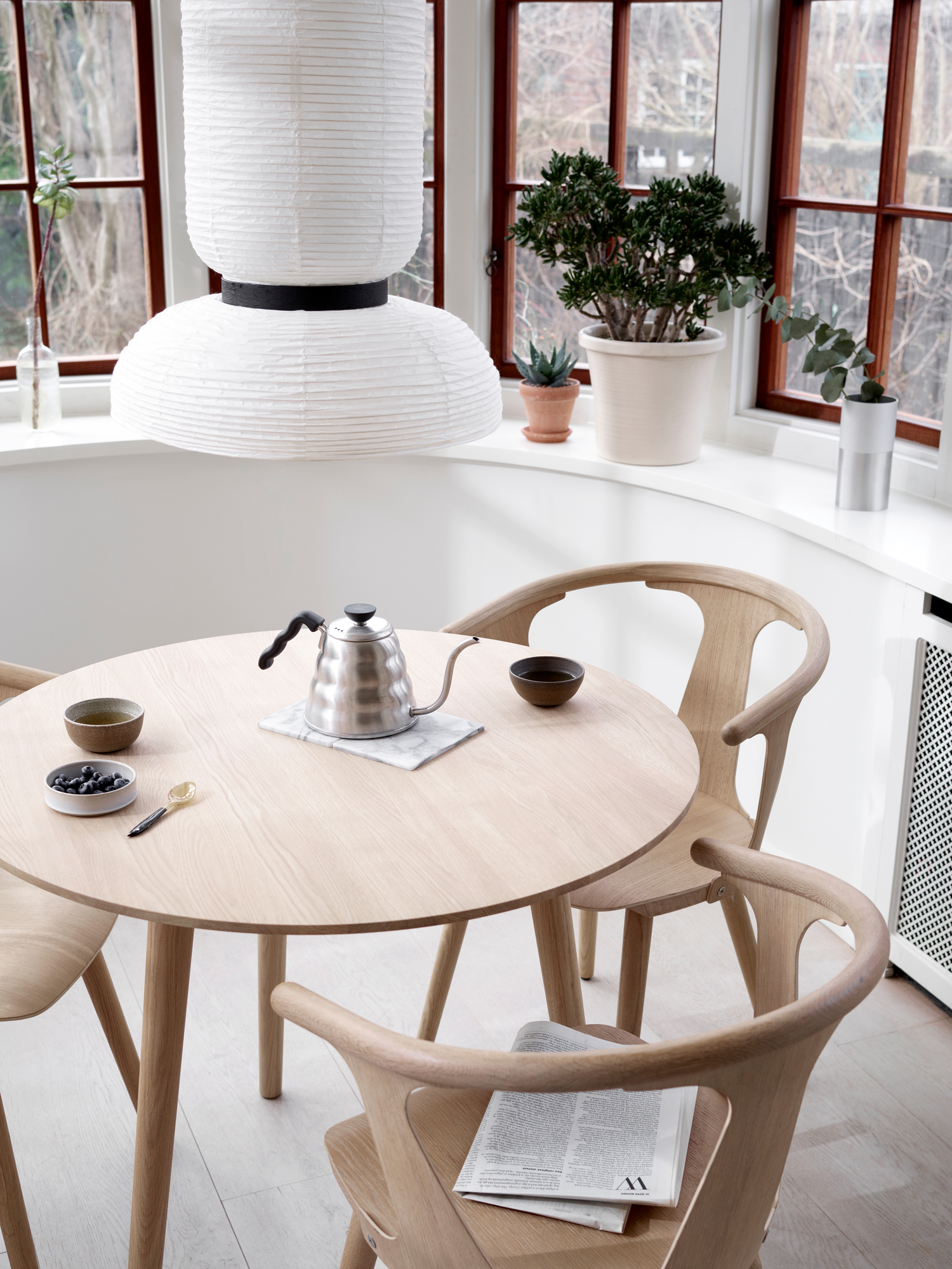 Esszimmer mit rundem Holztisch und drei In Between Chair Stühlen von AndTradition aus Eiche.